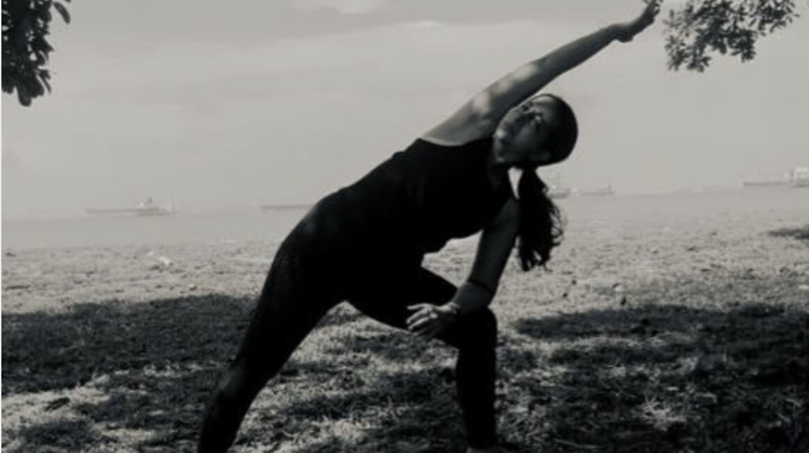 Karuna Grover in an extended side angle pose, seaside